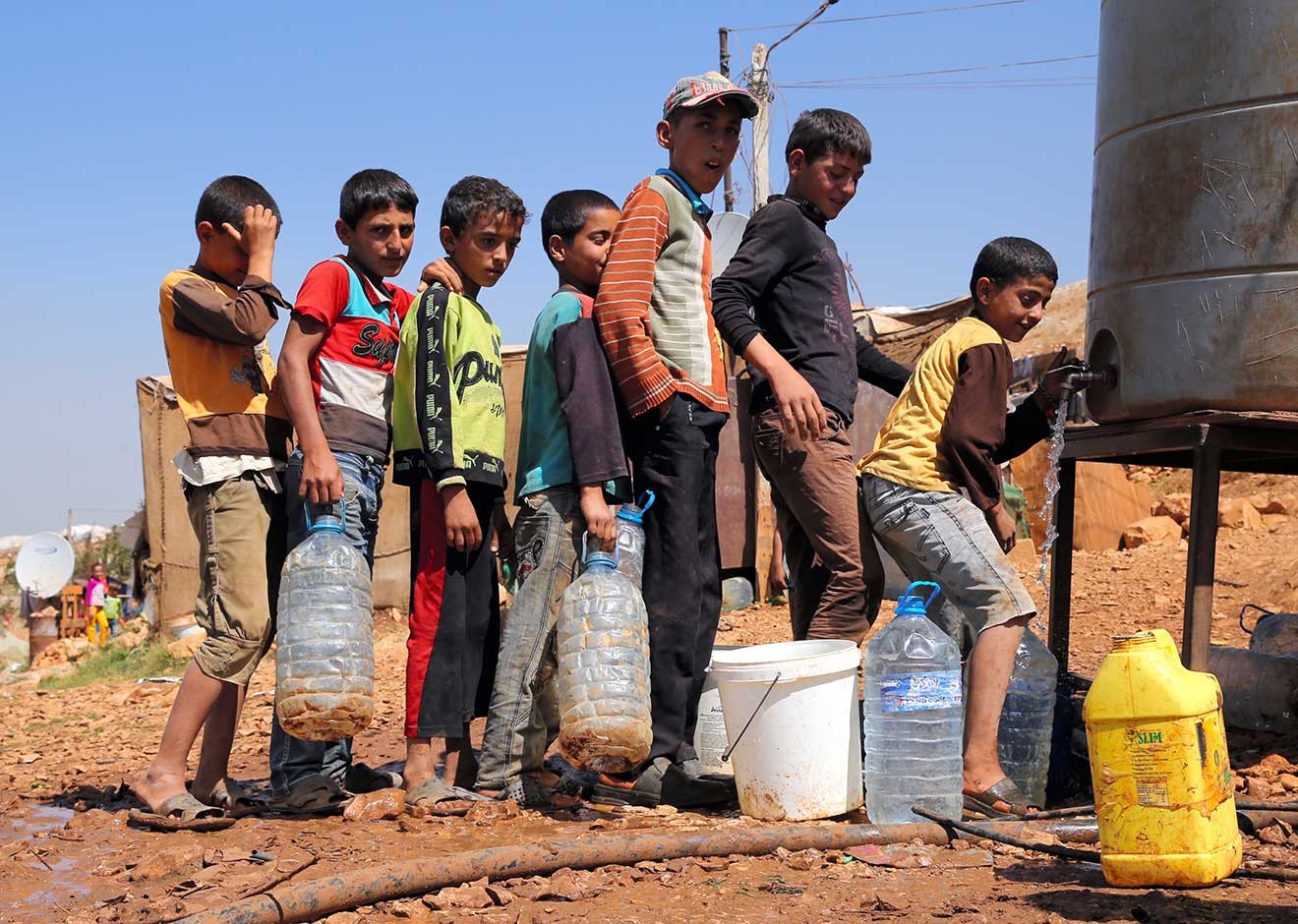<span>農場の水くみ場に並ぶシリア難民の子どもたち</span>